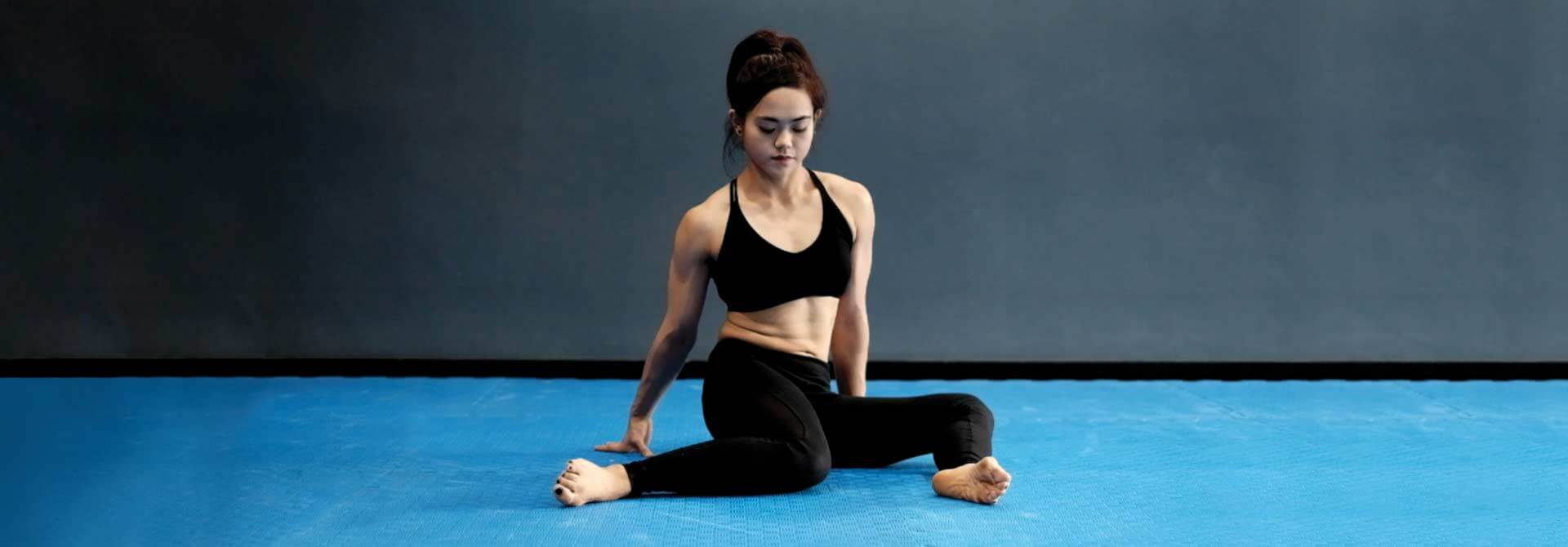 La atleta de GymnasticBodies demuestra los giros de cadera, un ejercicio que afloja suavemente las articulaciones de la cadera.